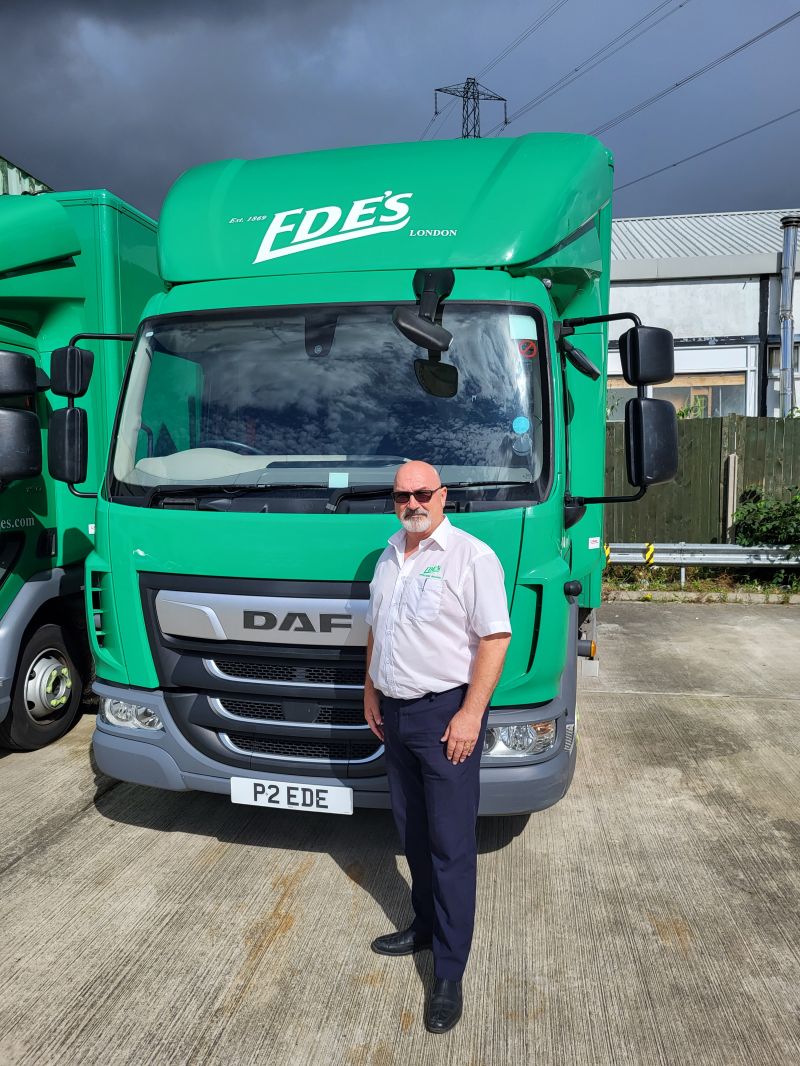 A man standing in front of two trucks.