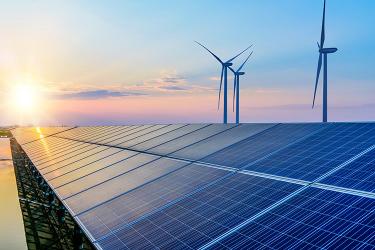 Solar panels and wind turbines at sunset, illustrating renewable energy sources.